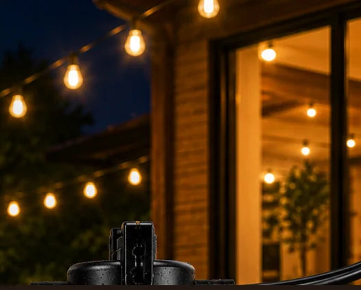 Solar string lights glowing over a patio at dusk